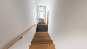 Eine Treppe führt zu einer Zwischenebene, über der eine Leuchte hängt.