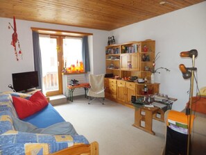 A cozy room with a bed, a desk, a chair, a bookshelf, and a lamp. - Wohnung Lippmeyer, (Splügen), by Interhome (Splügen)