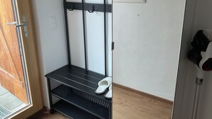 A hallway with a coat rack, a shoe shelf, and a door.