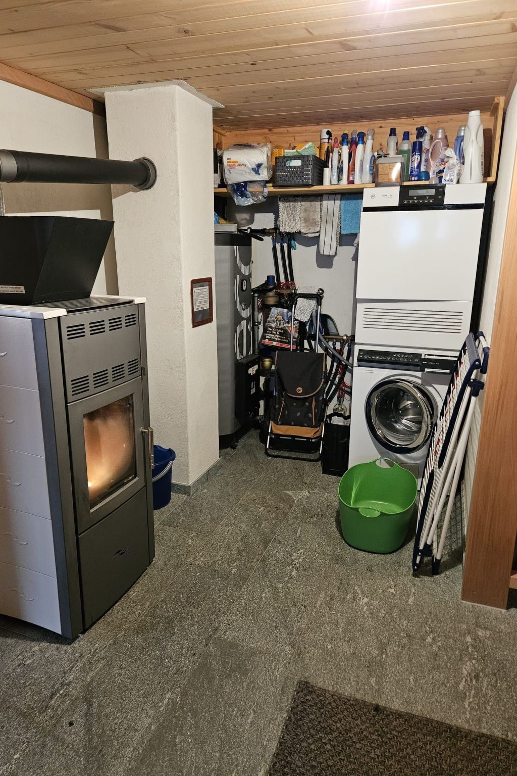 Une cuisine compacte équipée d’une cuisinière, d’un four et d’un lave-linge.