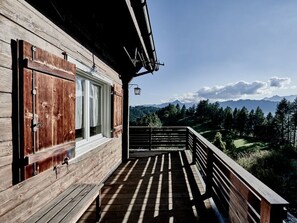A wooden deck with a view of a mountainous landscape.