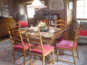 A dining area with a wooden table, chairs, and a chandelier. - Wohnung Etter Albertinihaus, (Splügen), by Interhome (Splügen)