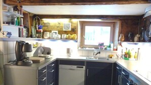 Una cocina compacta con lavavajillas, un lavabo y un ventanal.