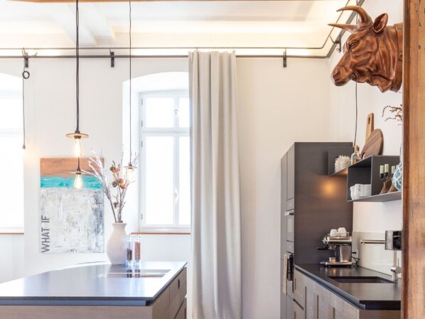 A modern kitchen with a central island, pendant lighting, and a rustic cow head decoration.