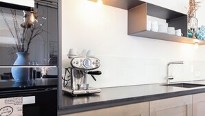 A modern kitchen with a built-in espresso machine, a sink, and a countertop.