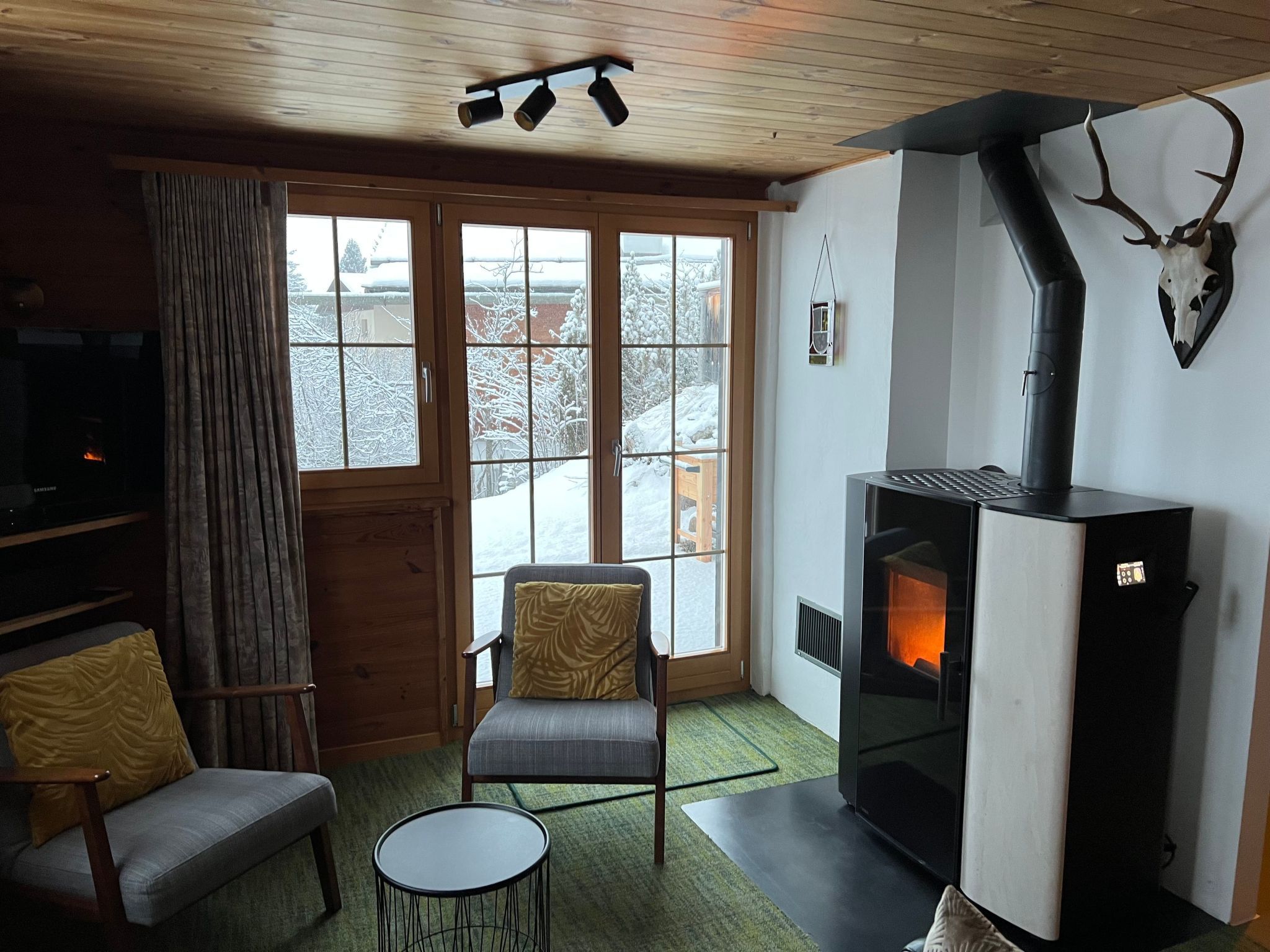 A cozy living room with a fireplace, a sofa, a chair, and a television.
