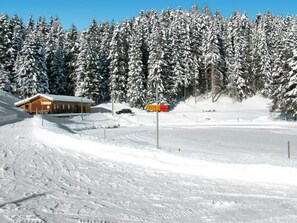 A snow-covered landscape with a lodge, a signpost, and a ski slope. - Haus Maran, (Oberurmein), by Interhome (Urmein)