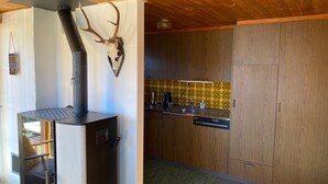 Cozinha moderna com armários de madeira, fogão embutido e uma caveira de veado decorativa.