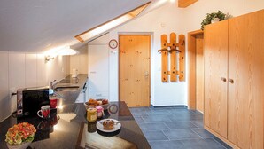 Une cuisine moderne avec un plan de travail noir, une machine à café et un saladier rempli de salade.