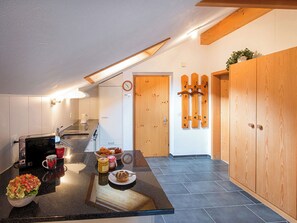 Eine moderne Küche mit schwarzem Arbeitsplatz, einer Kaffeemaschine und einer Salatschüssel.
