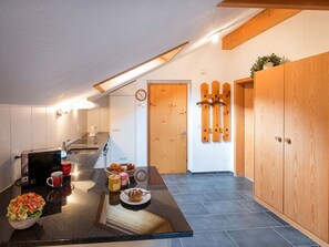 A modern kitchen with a built-in island, a microwave, and a coffee maker. - Ferienhaus Muntschi, (Andeer), by Interhome (Andeer)