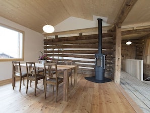 A wooden interior with a dining table, chairs, a fireplace, and a window. - Haus La Grobla, (Donat), by Interhome (Lohn GR)