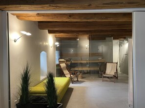 A modern interior with a glass partition, wooden ceiling beams, and seating areas. - Historisches Teiler-Haus, (Splügen), by Interhome (Splügen)