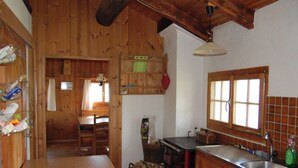 Un interior de madera con una zona de cocina, que incluye un lavamanos, armarios y una ventana.