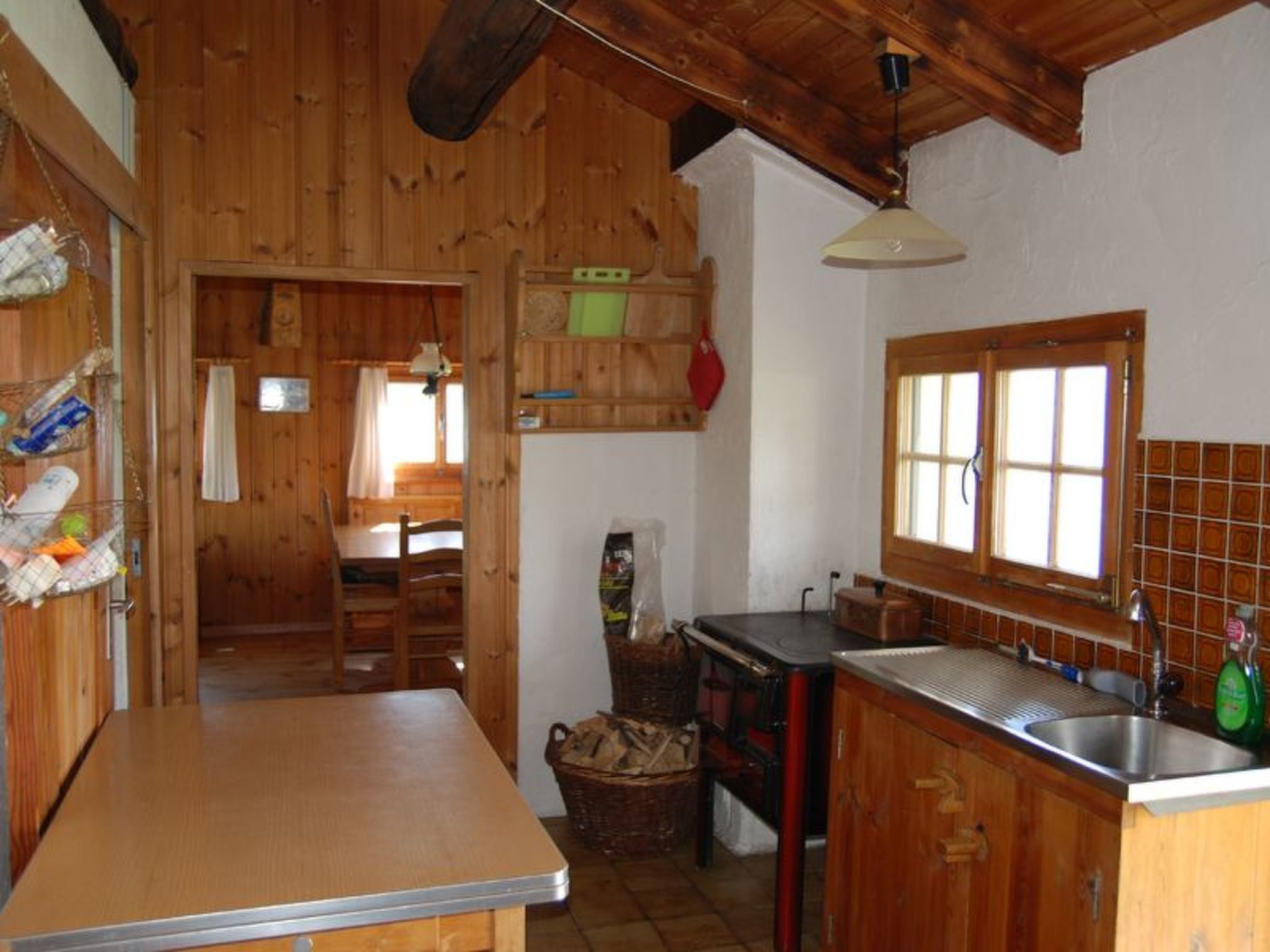Un intérieur en bois comprenant un espace cuisine avec un évier, une cuisinière et une table à manger.