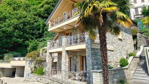 A stone building with a balcony, a staircase, and a palm tree. - Apartments Chalet al Lac - Flowers - Pool & Lake Como View (San Gregorio)