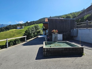 A clear outdoor area with a swimming pool, a wooden building, and a view of a green hillside. - im Försterhaus Dalin, (Dalin), by Interhome (Dalin)