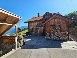 A wooden cabin with a stone foundation, a wooden porch, and a view of the mountains. - im Försterhaus Dalin, (Dalin), by Interhome (Dalin)