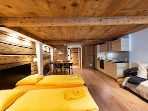 Une petite chambre comprenant un lit, une petite table et un coin cuisine.