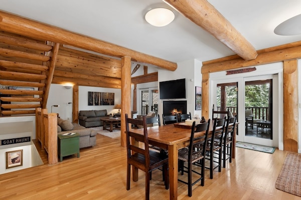 Gather around your rustic dining table while warm wood beams frame cozy evenings by the fireplace.