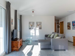 A modern living room with a sofa, television, and artwork on the wall. - Mengelt, (Splügen), by Interhome (Splügen)