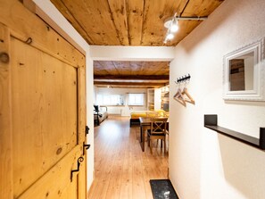 Een houten interieur met een eethoek, een bed en een kapstok.