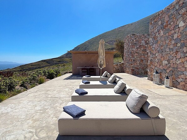 Eine Dachterrasse mit Außenbestuhlung und einer Steinmauer.