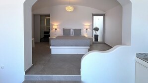 Un dormitorio con cama, lámparas de noche, una planta en maceta y vistas a través de un arco.