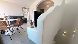 Un interior moderno con comedor, sofá y escalera.