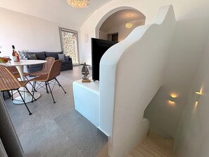 Ein modernes Interieur mit Essbereich, einer Couch und einer Treppe.