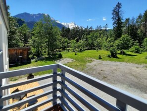 A balcony with a view of a mountainous landscape, a wooden deck, and a gravel path. - Ferienwohnungen Aktien 11, (Sils i.D.), by Interhome (Sils im Domleschg)