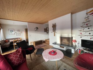 A living room with a sofa, chairs, a small table, a fireplace, and a television. - Wohnung Ohlenroth-Kalberer, (Sarn-Lescha). by Interhome (Sarn)