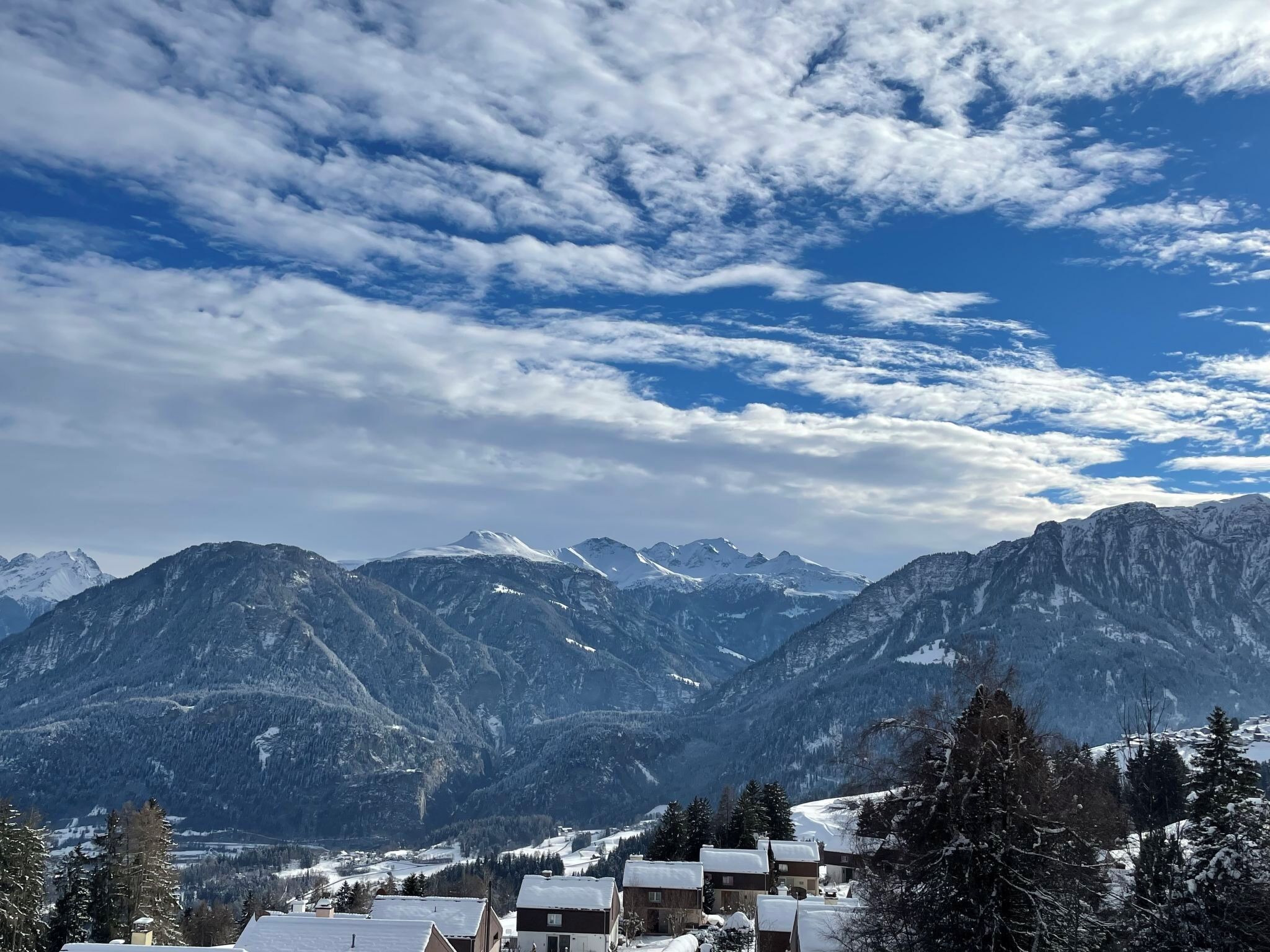 A mountainous landscape with snow-covered buildings and a clear sky.