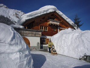 A wooden chalet with a balcony, surrounded by snow. - Ferienwohnungen Teuriblick A&B, (Splügen), by Interhome (Splügen)