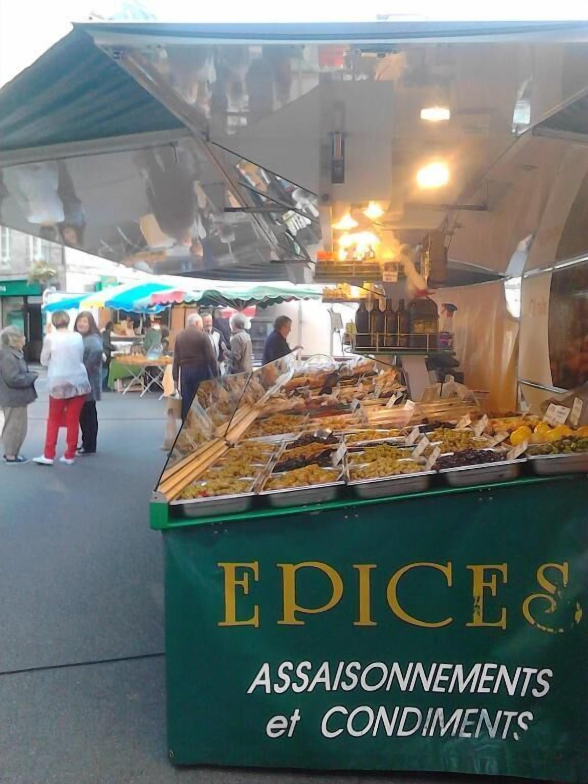 Un puesto de mercado con un letrero que dice 'EPICES & ASSAISONNEMENTS et CONDIMENTS'.