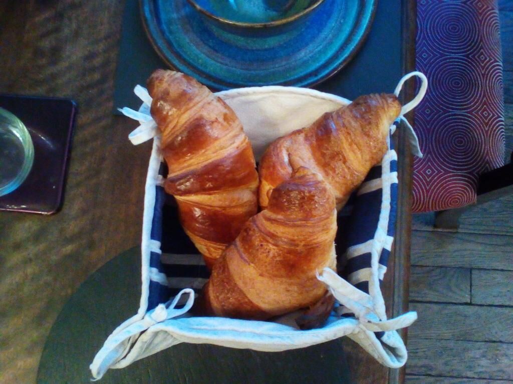 A basket containing croissants on a table.