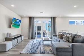 A modern living room with a sofa, coffee table, and artwork on the wall. - Elevated Luxe Condo near Disney with Resort & Waterpark Access - B42-247 (Kissimmee)