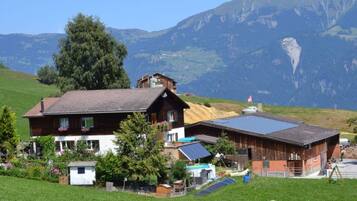 Ein Chalet mit geneigtem Dach, Solaranlagen und Bergblick.