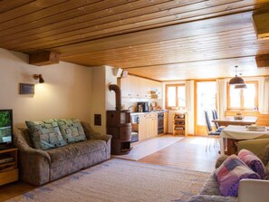 A cozy living room with a sofa, a television, and a fireplace.