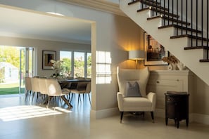 Ein modernes Interieur mit Essbereich, Treppe und Blick ins Freie.
