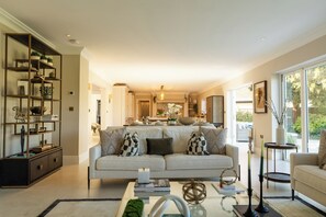 A modern living room with a sofa, coffee table, and a bookshelf.