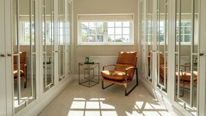 Quarto com uma janela grande, uma cadeira e um radiador.