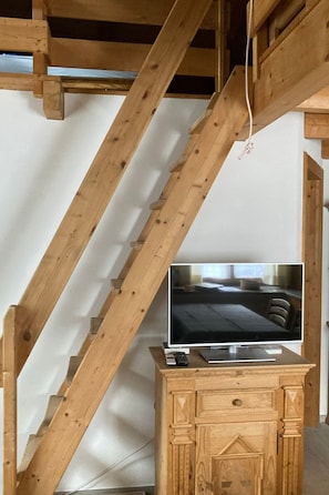 A television on a wooden cabinet in a room with exposed wooden beams. - Haus Fravgia veglia, (Andeer), by Interhome (Andeer)