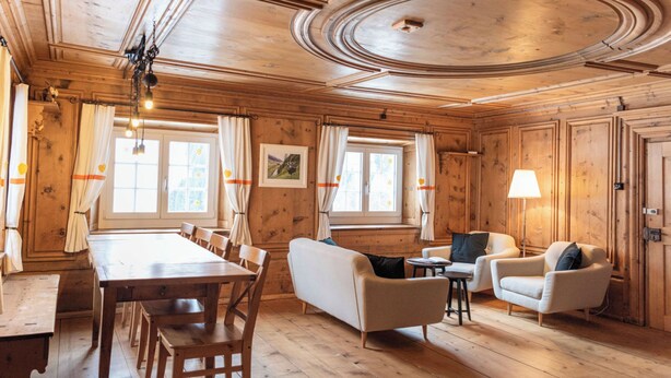 Un intérieur en bois comprenant une table à manger, des chaises, un canapé et une lampe.