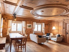 Un intérieur en bois comprenant une table à manger, des chaises, des canapés et une lampe.