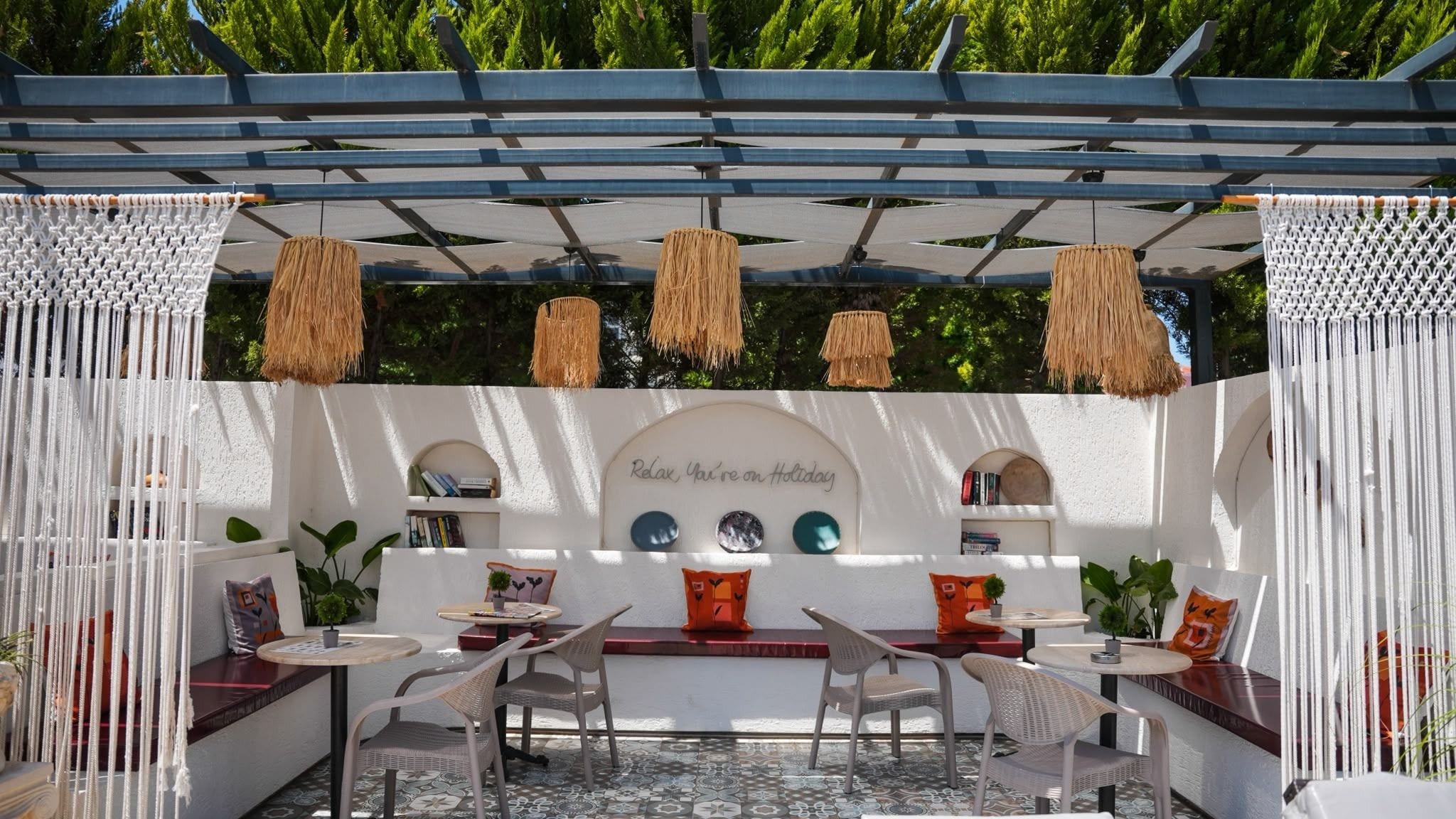 An outdoor seating area with white walls, a central table, and chairs.