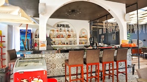 A bar area with a sign reading 'APRIL' and a counter with bar stools. - MENDOS GARDEN EXCLUSIVE (Muğla)
