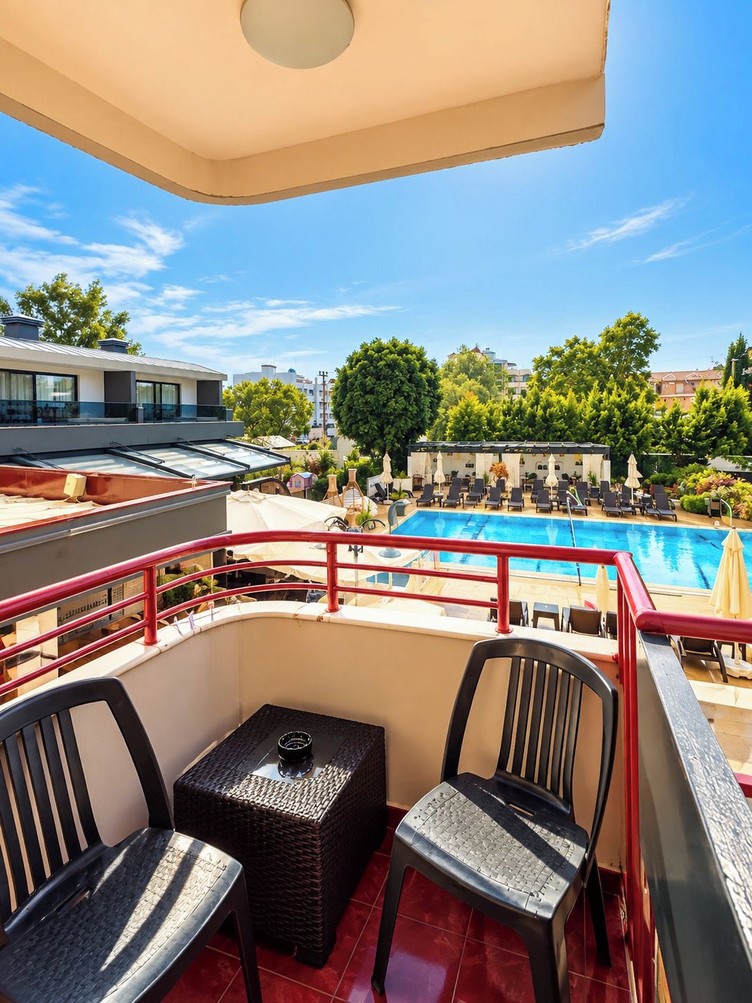 Une terrasse sur le toit avec une piscine, des espaces de détente en plein air et une vue dégagée sur les environs.