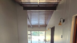 A hallway with a tiled floor, wooden ceiling beams, and wall-mounted light fixtures. - Fantastic 4-bedroom house in pleasant Gillitts for your getaway (Gillitts)