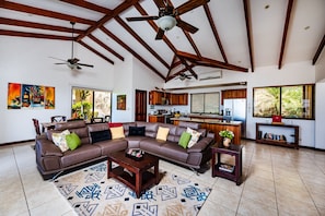 A spacious living room with a sectional sofa, a coffee table, and a dining area with a table and chairs.